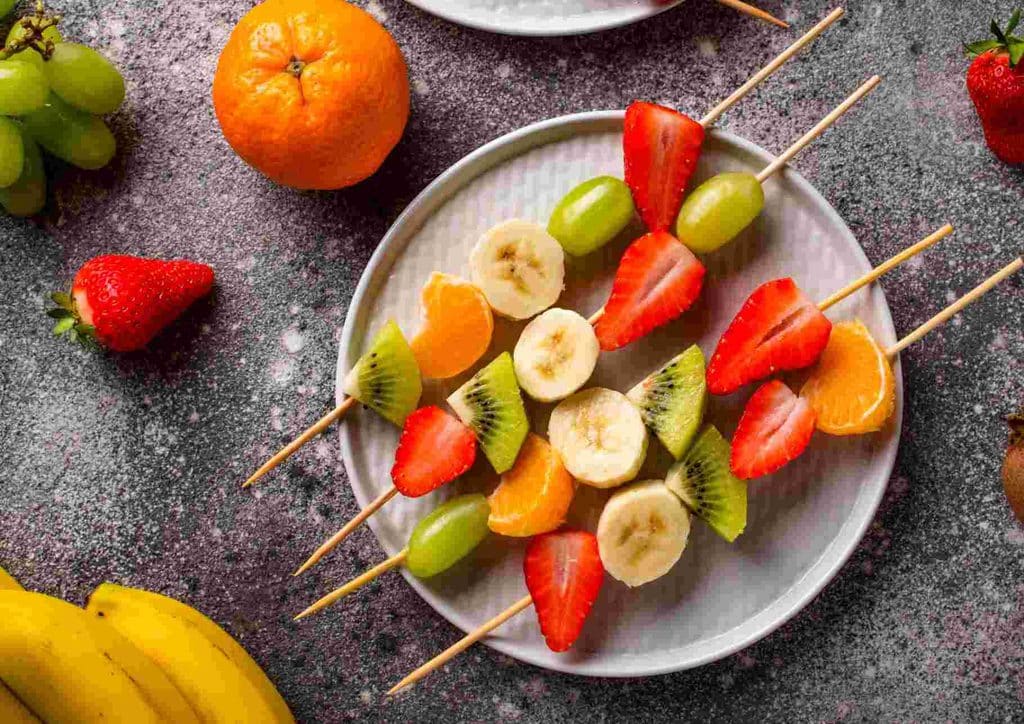 Healthy Snacks for Weight Loss That Actually Keep You Full 12 A vibrant assortment of fruit skewers on a plate, showcasing fresh strawberries, bananas, and oranges.