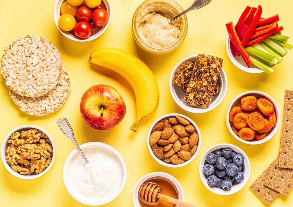 Healthy Snacks for Weight Loss That Actually Keep You Full 19 An assortment of healthy foods displayed in bowls, including fruits, vegetables, nuts, and grains.
