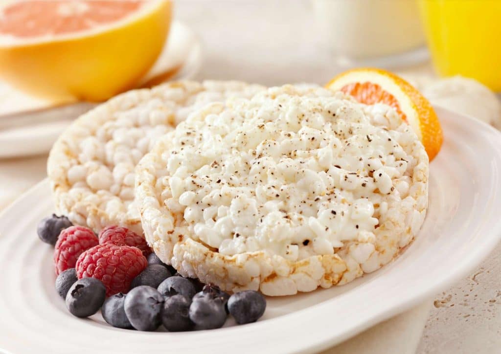 Healthy Snacks for Weight Loss That Actually Keep You Full 15 A plate of rice accompanied by assorted fruits and a glass of orange juice on a table.