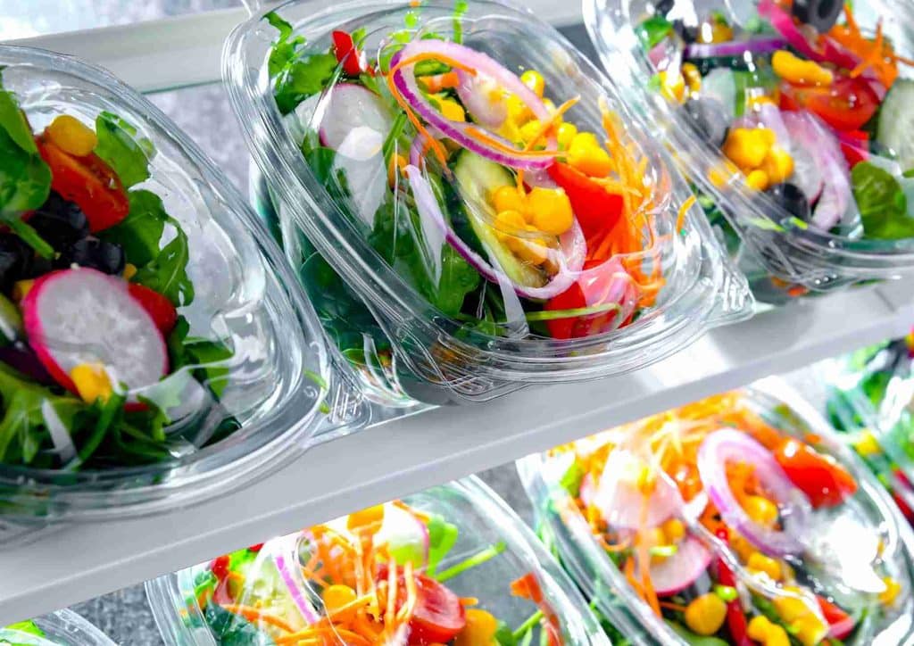 Easy Meals for Weight Loss When You're Short on Time 32 A refrigerator filled with various plastic containers of colourful salads, showcasing fresh vegetables and ingredients