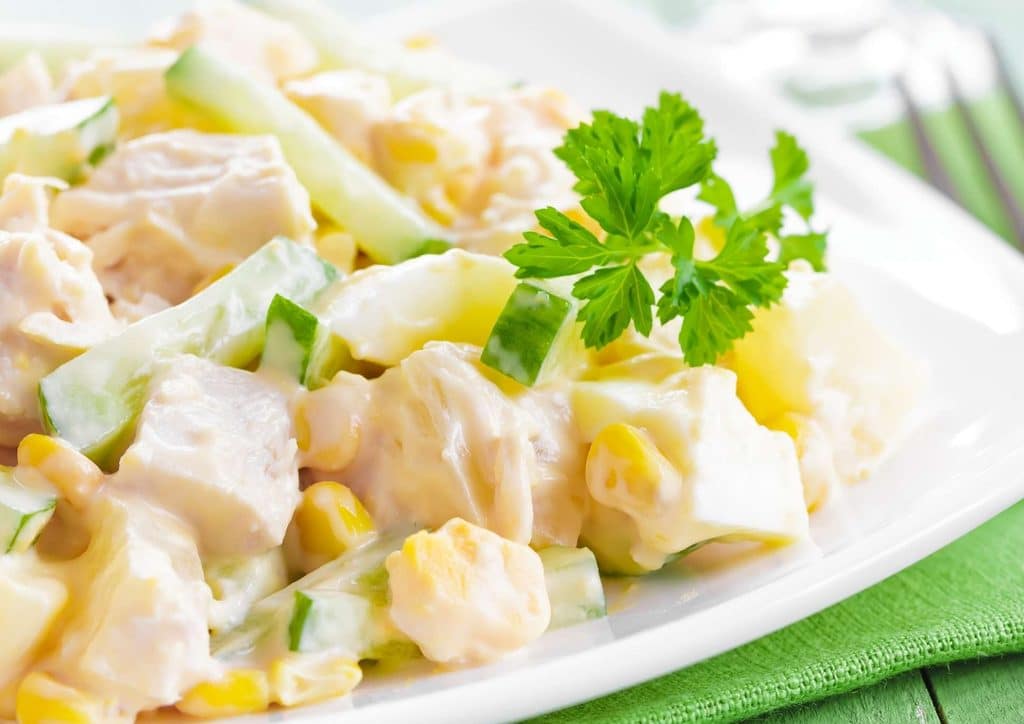 Healthy Dinners for Weight Loss: Easy Weeknight Ideas 38 A white plate featuring a serving of chicken salad garnished with fresh cucumber slices.