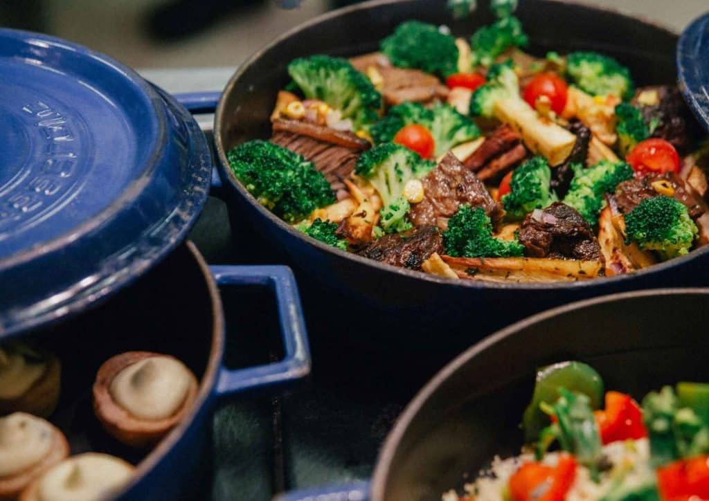 Easy Meals for Weight Loss When You're Short on Time 35 A collection of colourful dishes in blue pots, simmering on a stove, showcasing a variety of food preparations.