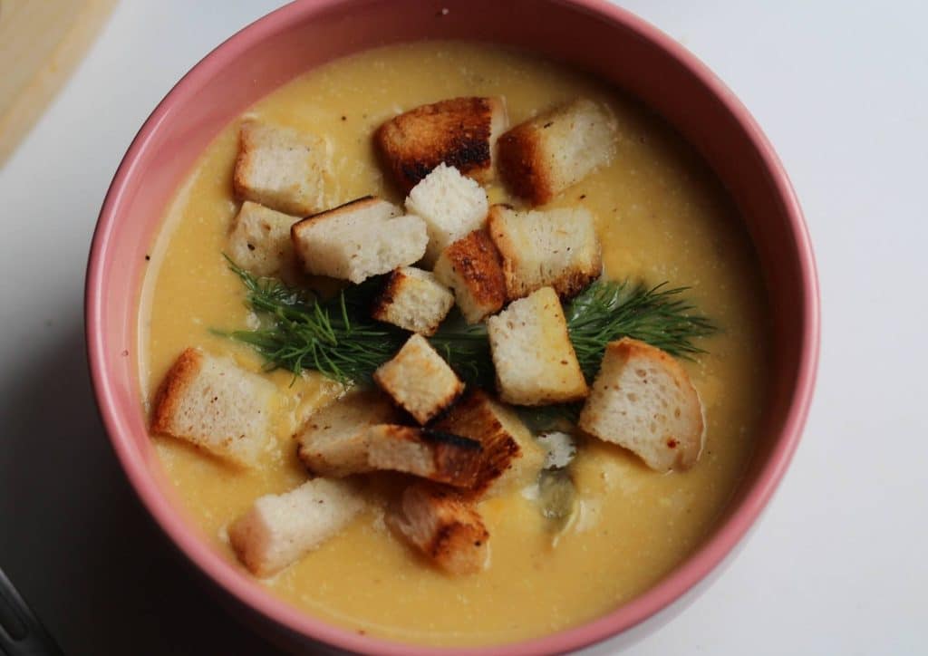 Healthy Lunches for Weight Loss: Work and Home Ideas 26 A bowl of soup garnished with croutons, accompanied by a spoon resting beside it.