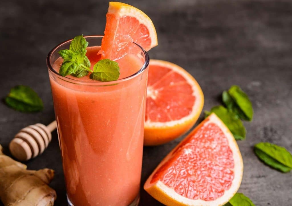 High Fibre Diet for Weight Loss: Why Fibre Keeps You Full 46 A glass of grapefruit juice garnished with fresh mint leaves and slices of ginger on a wooden table.