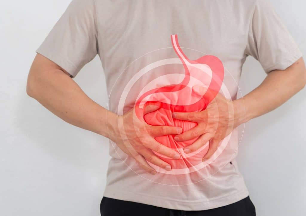 High Fibre Diet for Weight Loss: Why Fibre Keeps You Full 29 Man clutching his abdomen, showing signs of discomfort due to stomach pain.