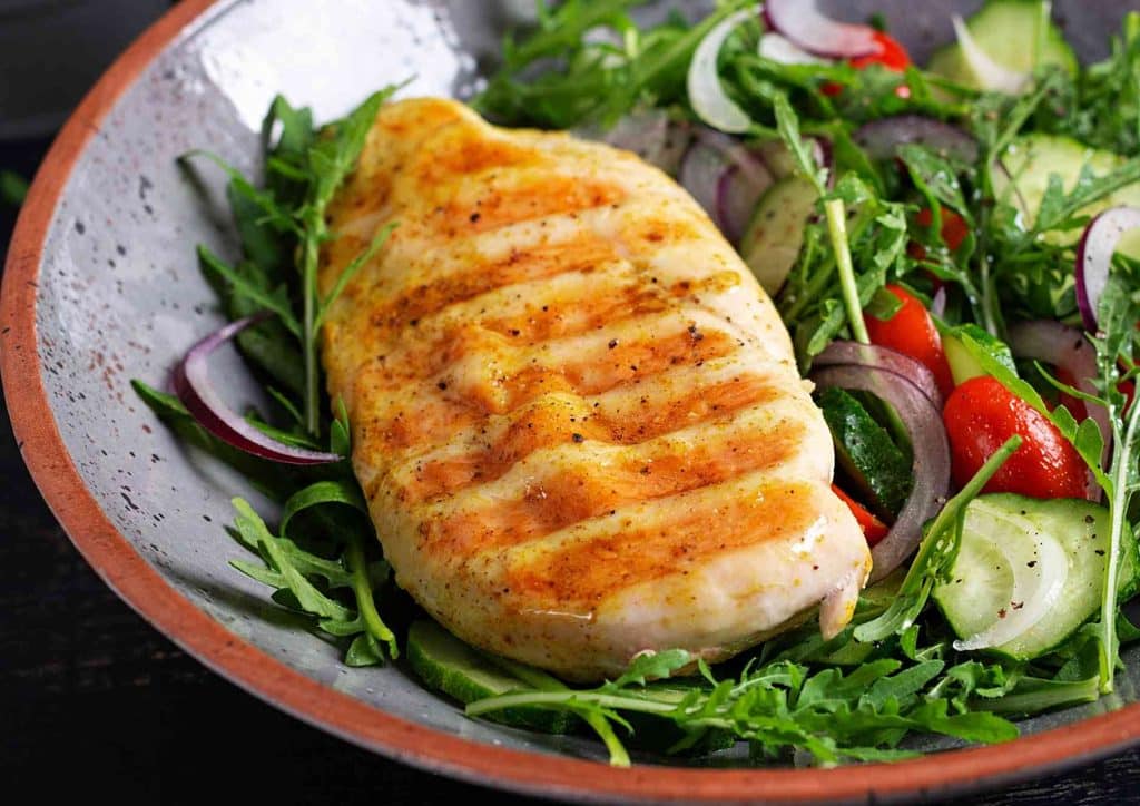 Healthy Dinners for Weight Loss: Easy Weeknight Ideas 39 Grilled chicken breast served on a plate alongside a fresh garden salad.