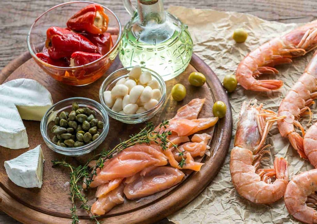 Is the Mediterranean Diet Good for Weight Loss? 16 A plate filled with assorted seafood, including shrimp, mussels, and garnished with fresh herbs and lemon slices.