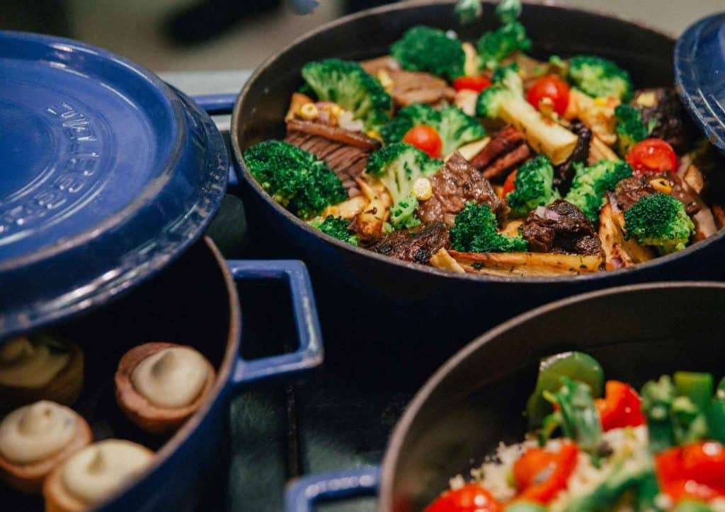 High Fibre Diet for Weight Loss: Why Fibre Keeps You Full 32 Several blue pots on a stove filled with diverse foods, highlighting a vibrant assortment of culinary creations.