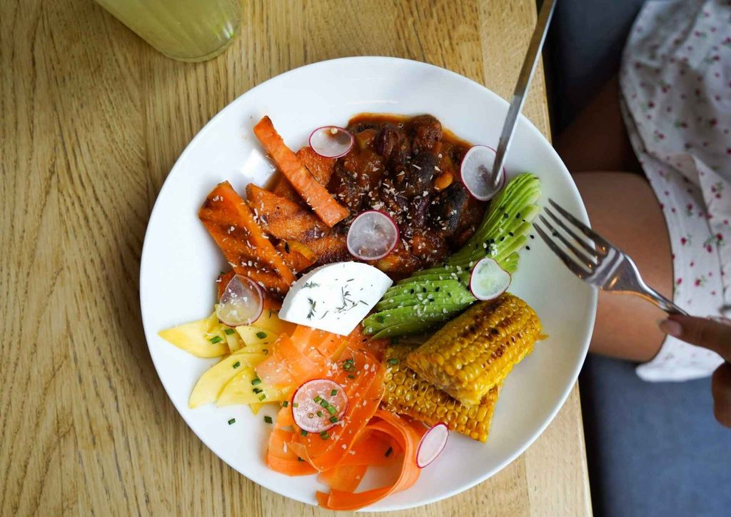 Vegetarian Diet for Weight Loss: How to Get It Right 22 A beautifully arranged plate of food featuring various ingredients rests on a wooden table surface.