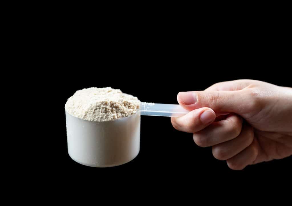 Is Whey Protein Good for Weight Loss? 35 A person holds a scoop of powder in their hand, showcasing the texture and quantity of the substance.