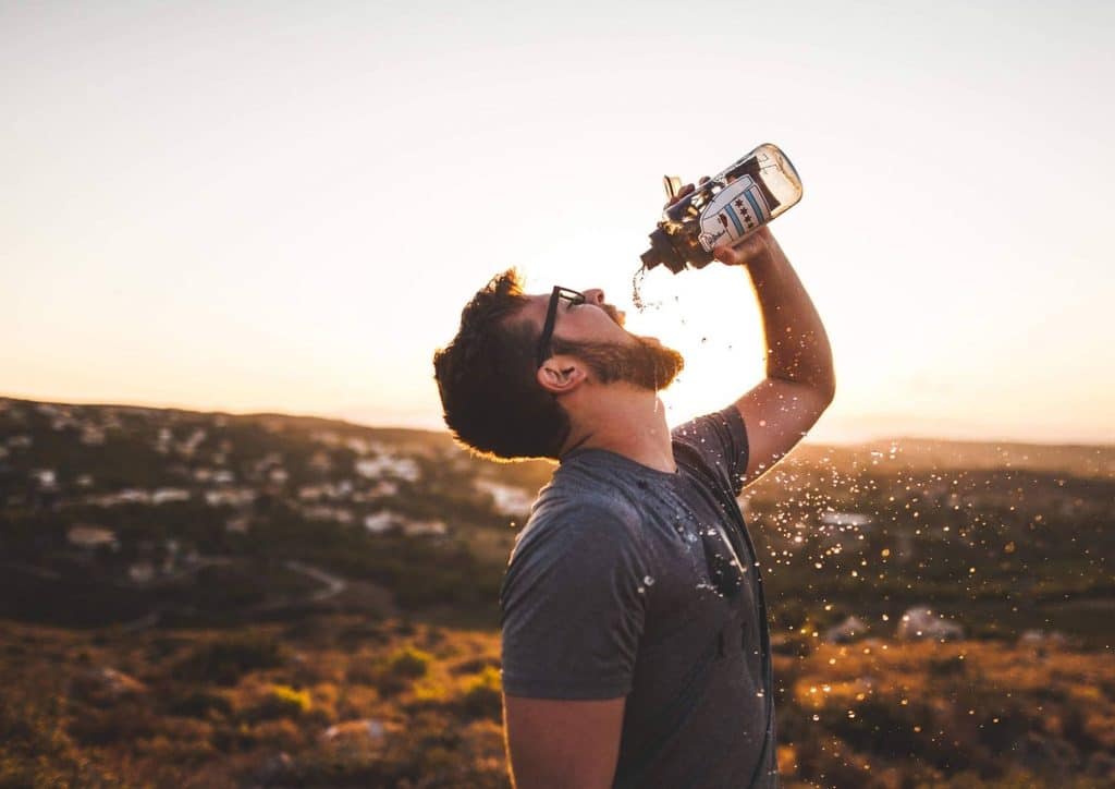 High Fibre Diet for Weight Loss: Why Fibre Keeps You Full 43 A man is drinking water from a clear plastic bottle, appearing refreshed and hydrated.