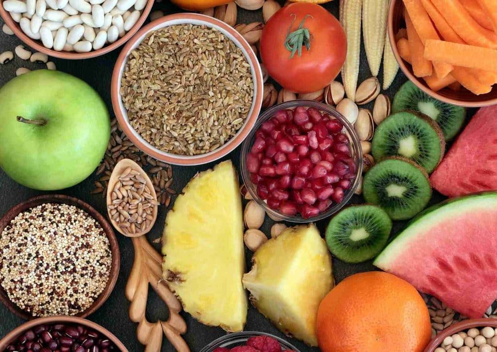 High Fibre Diet for Weight Loss: Why Fibre Keeps You Full 28 Bowls filled with an array of fresh fruits and vegetables, highlighting their vibrant colours and diverse textures.