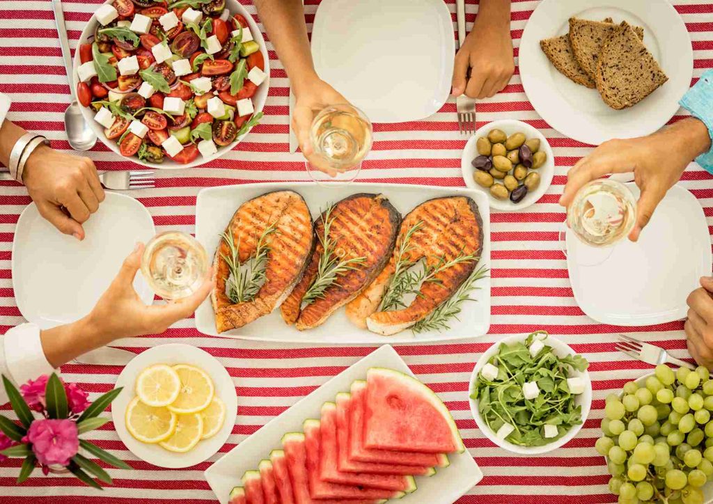 Is the Mediterranean Diet Good for Weight Loss? 32 A diverse group of people enjoying a meal together at a table, sharing food and conversation.