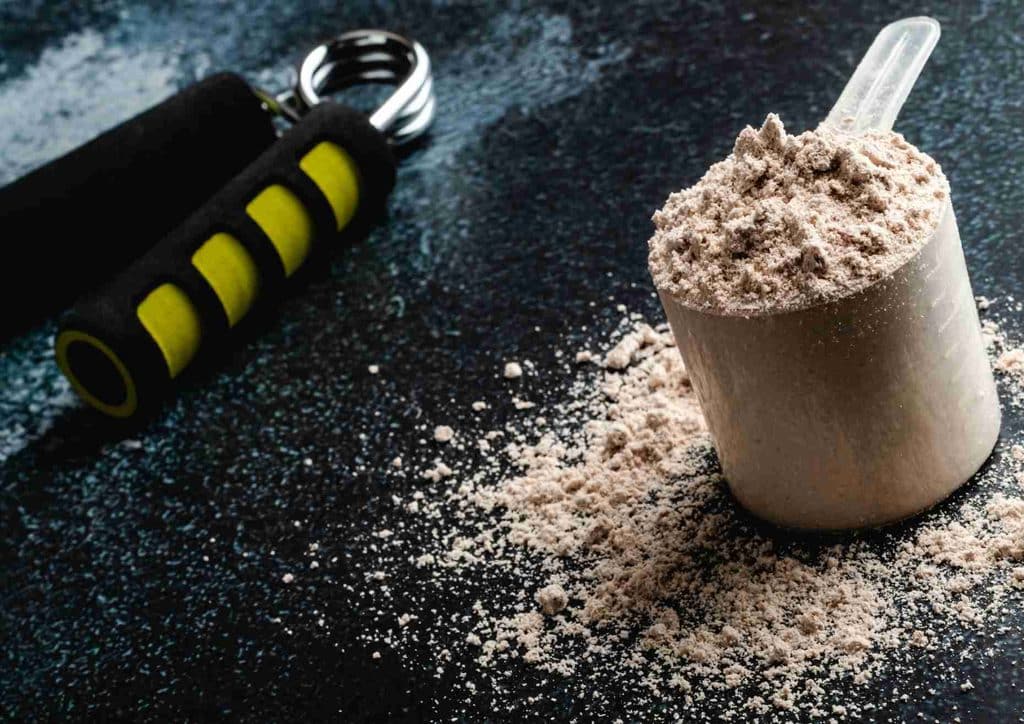 Is Whey Protein Good for Weight Loss? 33 Protein powder in a blender with a spoon resting inside, ready for mixing.