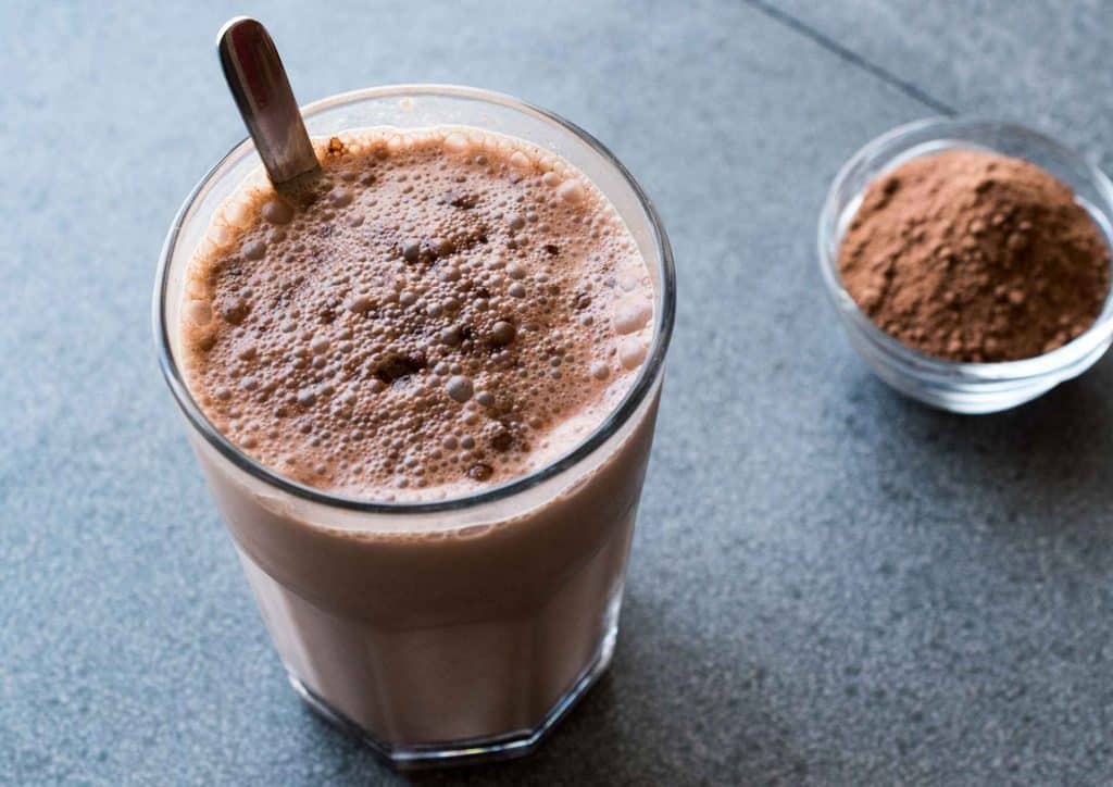 Is Whey Protein Good for Weight Loss? 34 A glass of chocolate smoothie with a spoon resting on the rim, showcasing a rich, creamy texture.