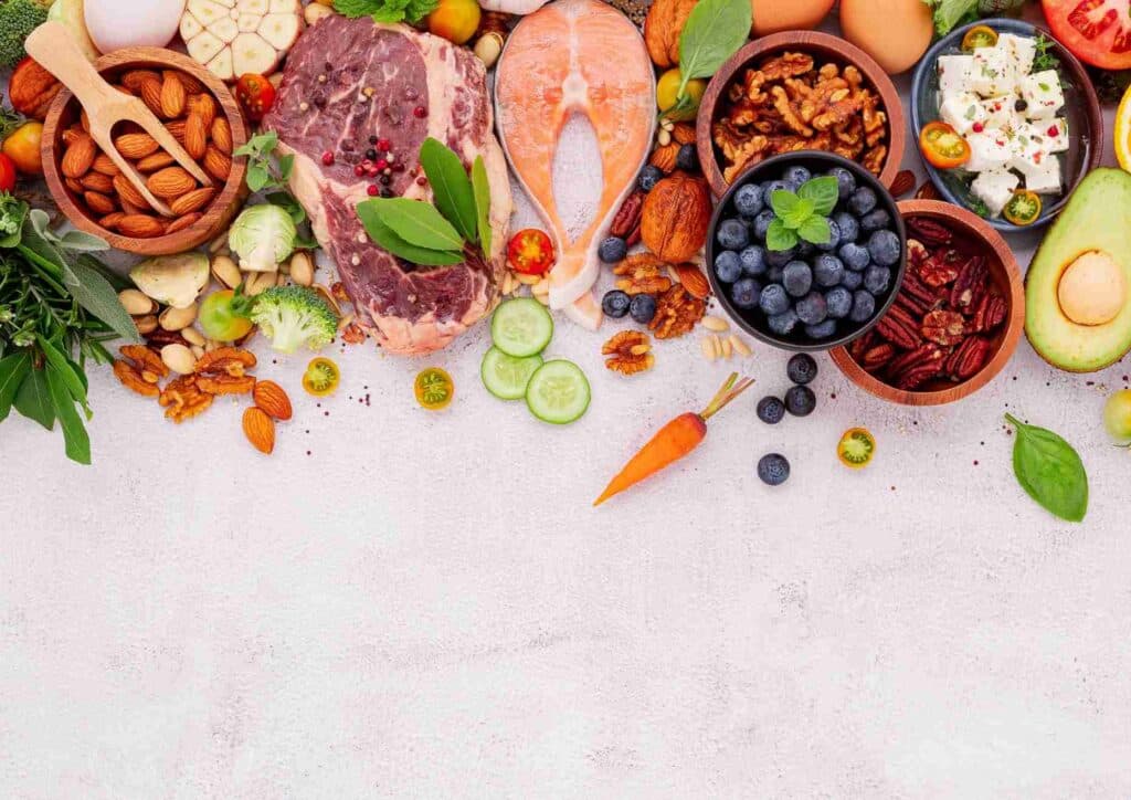 Keto vs Low Carb for Weight Loss: Which Is Better? 16 An assortment of healthy foods, including fruits, vegetables, and grains, displayed in bowls on a wooden surface.