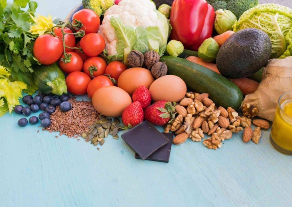 Keto vs Low Carb for Weight Loss: Which Is Better? 31 A colourful assortment of fruits and vegetables displayed on a blue table, showcasing their vibrant colours and textures.