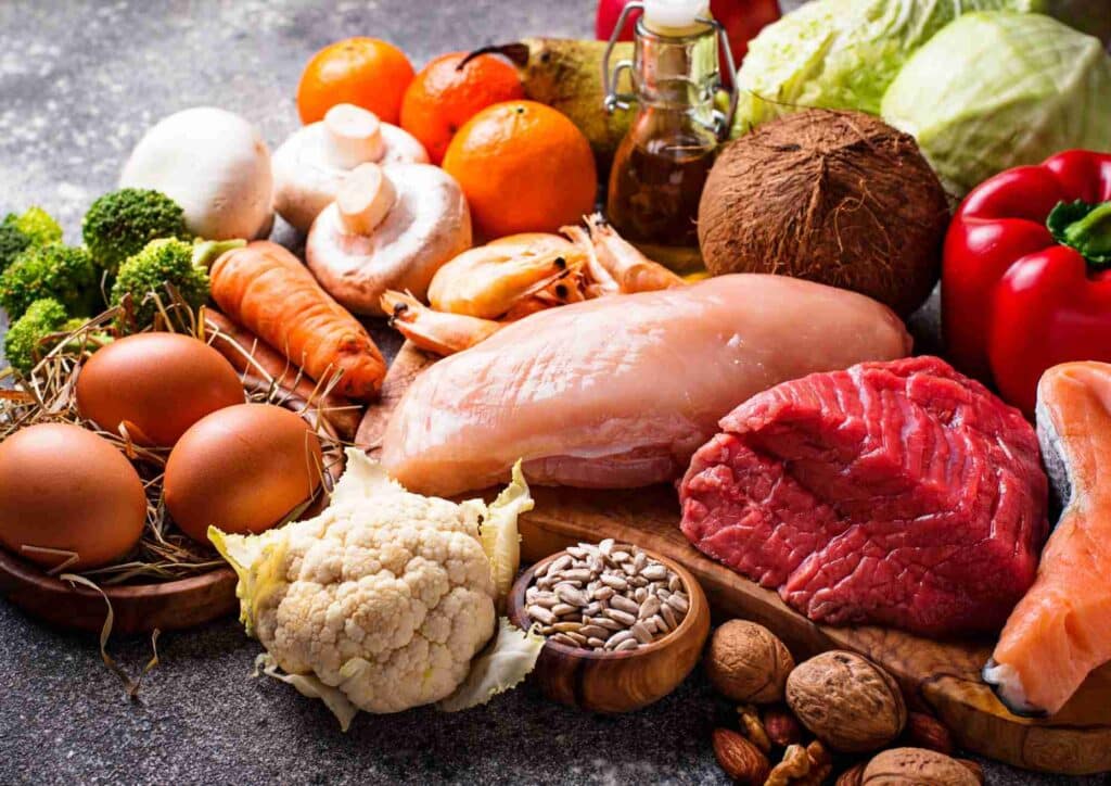 Keto vs Low Carb for Weight Loss: Which Is Better? 8 A variety of heart-healthy foods including fruits, vegetables, nuts, and whole grains displayed on a wooden table.