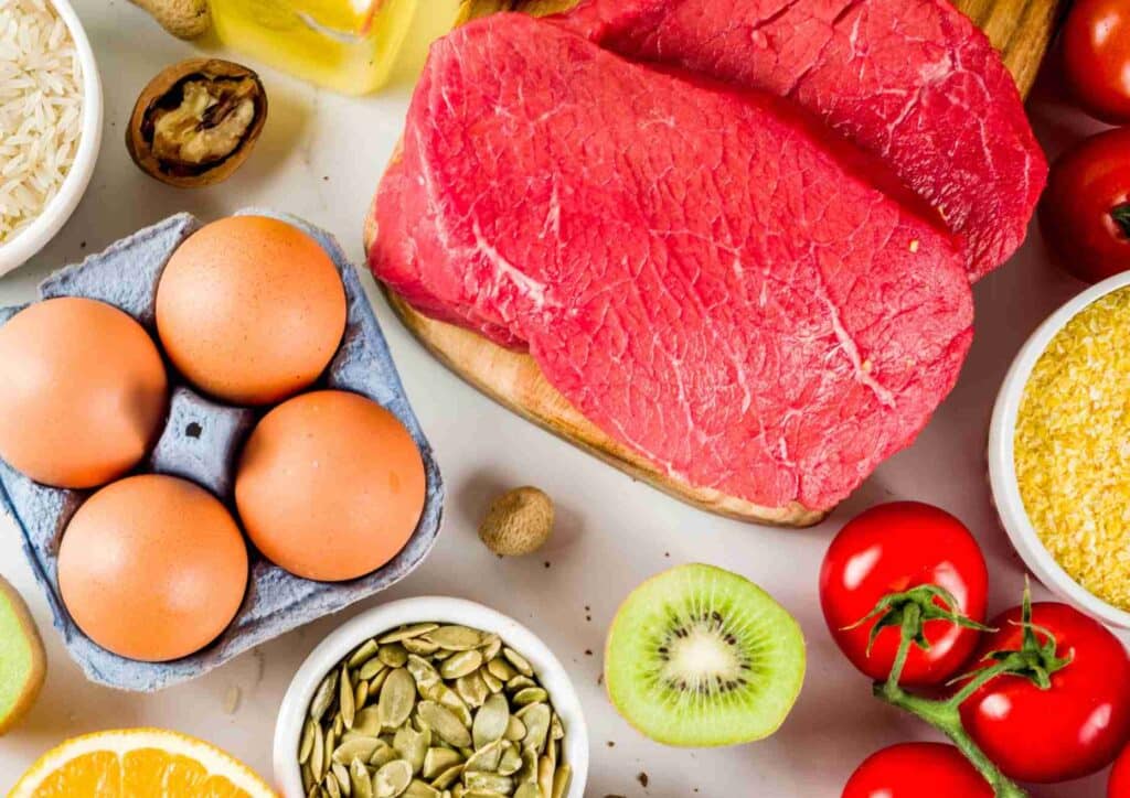 Keto vs Low Carb for Weight Loss: Which Is Better? 10 A variety of heart-healthy foods including fruits, vegetables, nuts, and whole grains displayed on a wooden table.