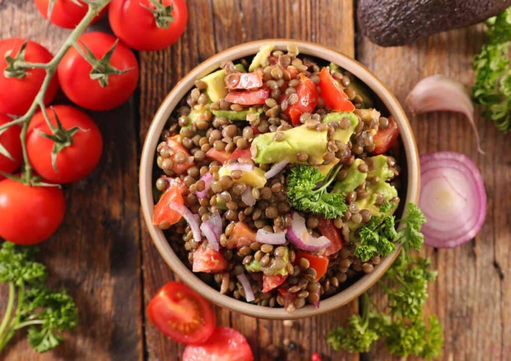 Keto vs Low Carb for Weight Loss: Which Is Better? 36 A bowl of lentil salad featuring diced tomatoes, avocado, and assorted fresh vegetables.