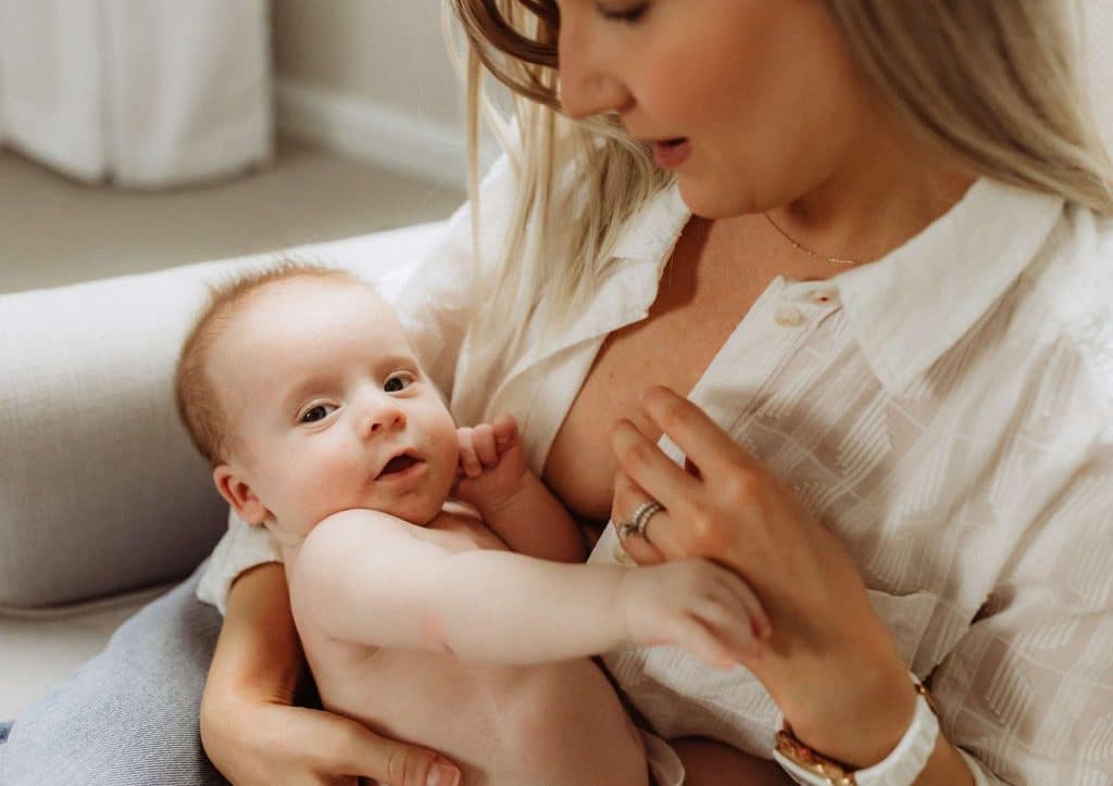 Losing Weight While Breastfeeding: What's Safe and Realistic 45 A woman gently breastfeeding her baby while seated comfortably.