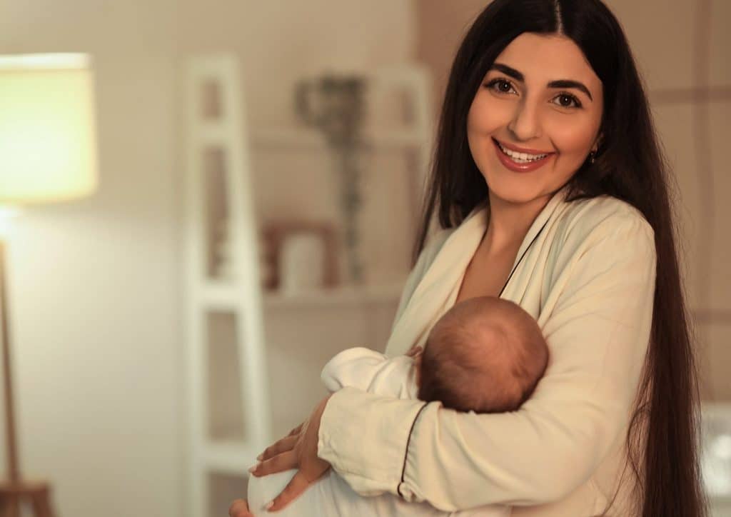 Losing Weight While Breastfeeding: What's Safe and Realistic 44 A woman gently cradles a baby in her arms, showcasing a tender moment of care and affection.