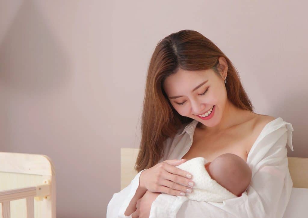 Losing Weight While Breastfeeding: What's Safe and Realistic 46 A woman gently cradles a baby in her arms, showcasing a tender moment of care and affection.