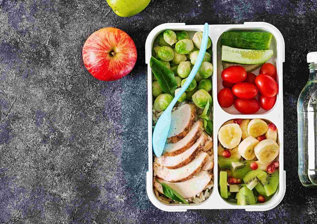 Healthy Lunches for Weight Loss: Work and Home Ideas 23 A lunch box containing grilled chicken, assorted vegetables, and fresh fruit, arranged neatly for a balanced meal.