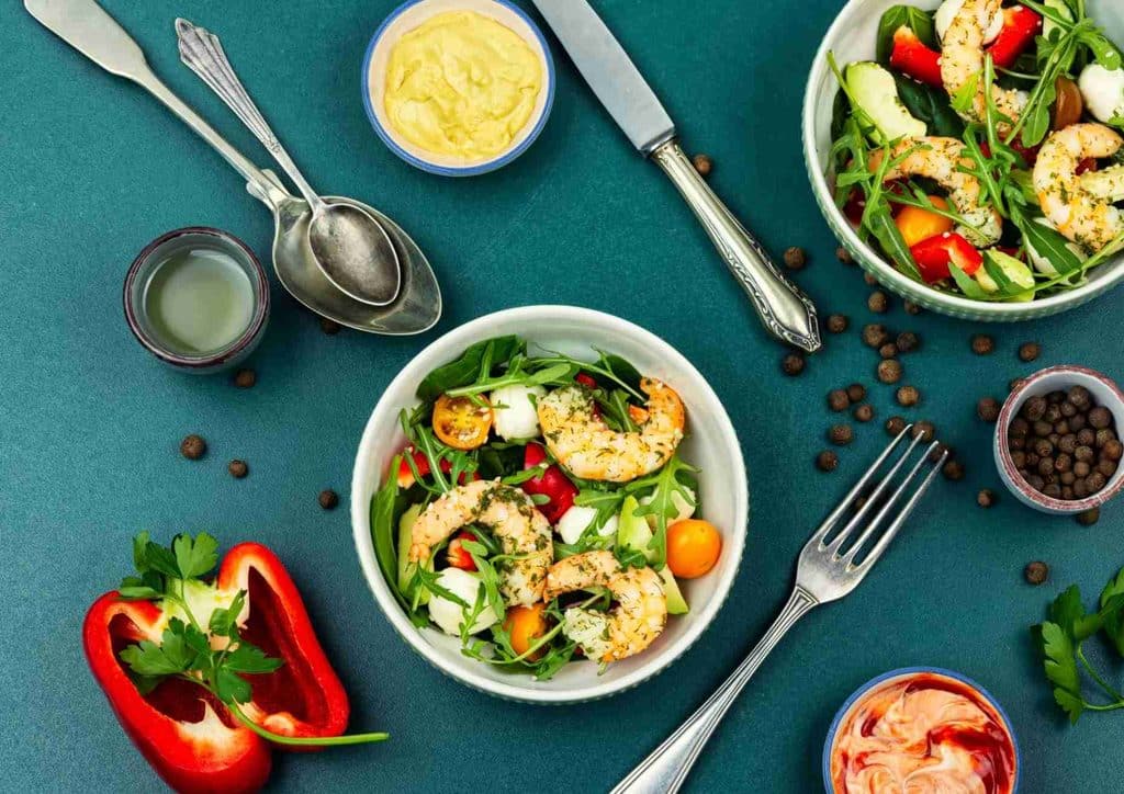 Healthy Lunches for Weight Loss: Work and Home Ideas 19 A bowl of salad featuring shrimp, tomatoes, peppers, and various fresh ingredients.