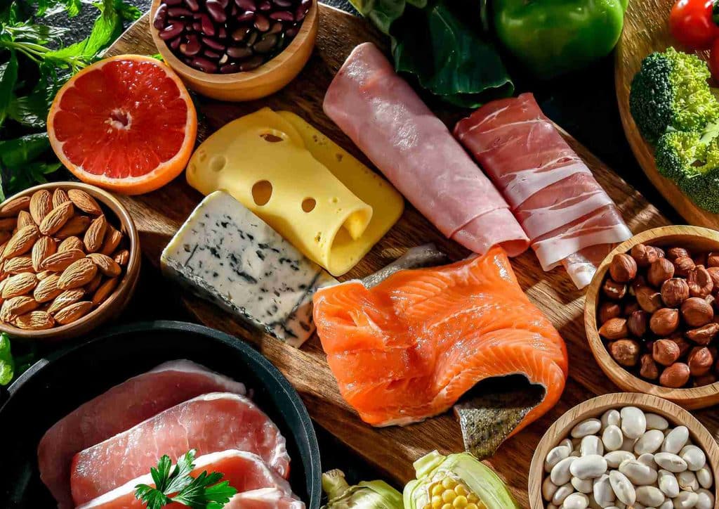 Is the Mediterranean Diet Good for Weight Loss? 39 A diverse spread of food items including fresh vegetables, assorted nuts, fruits, and cooked meat on a rustic surface.