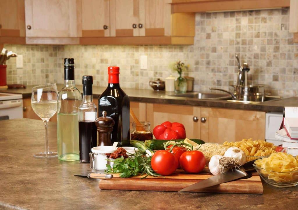 Is the Mediterranean Diet Good for Weight Loss? 31 A kitchen counter featuring a wooden cutting board, several wine bottles, and an open bottle of wine.