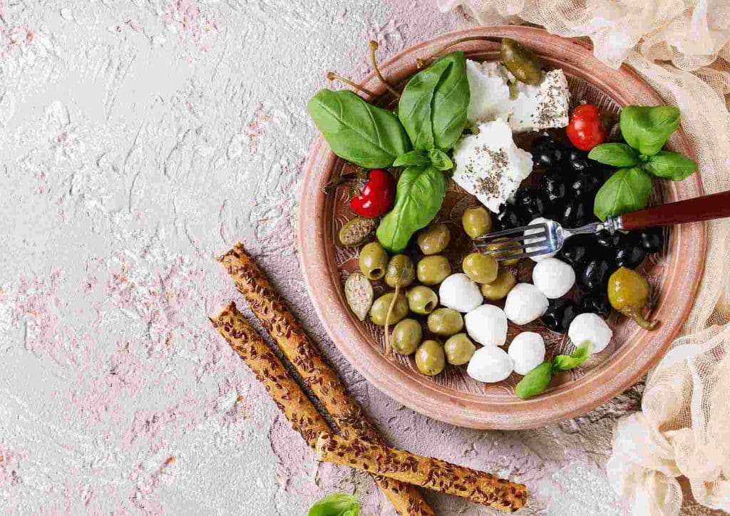 Is the Mediterranean Diet Good for Weight Loss? 19 A plate featuring assorted olives, cheese, and various appetizers arranged artfully for a gourmet presentation.