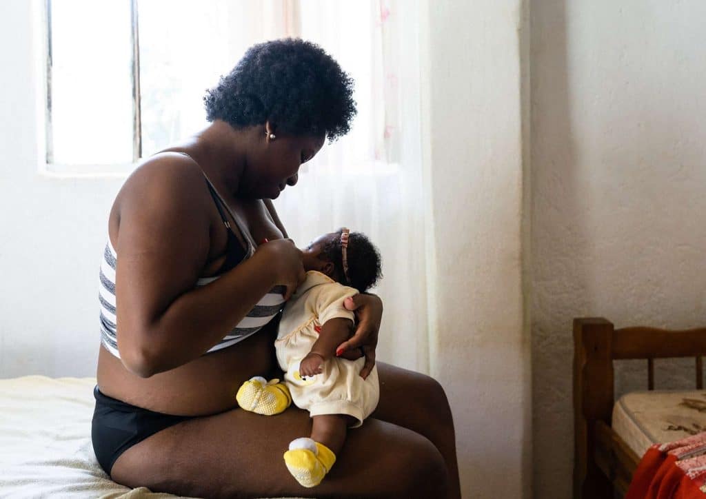 Losing Weight While Breastfeeding: What's Safe and Realistic 40 A woman breastfeeding her baby in a cozy room, surrounded by soft lighting and comfortable furnishings.