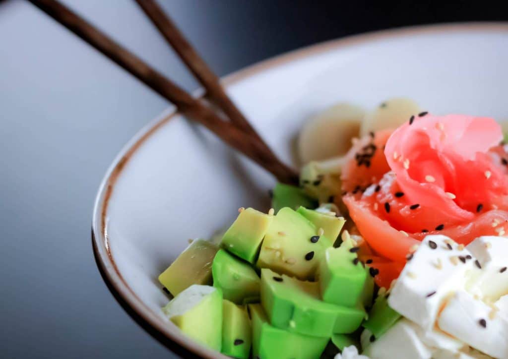 Vegetarian Diet for Weight Loss: How to Get It Right 28 A bowl of sushi featuring avocado, salmon, and cucumber arranged artfully.