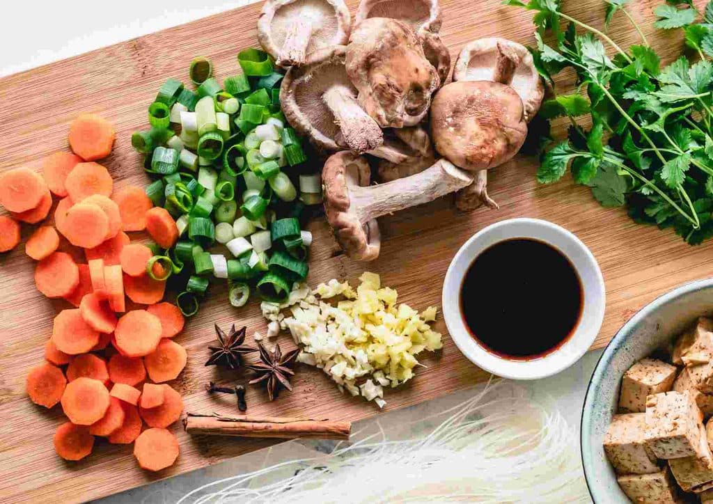 Postpartum Weight Loss: A Gentle, Realistic Guide 21 Fresh vegetables and sliced proteins arranged on a wooden cutting board, ready for stir fry preparation.