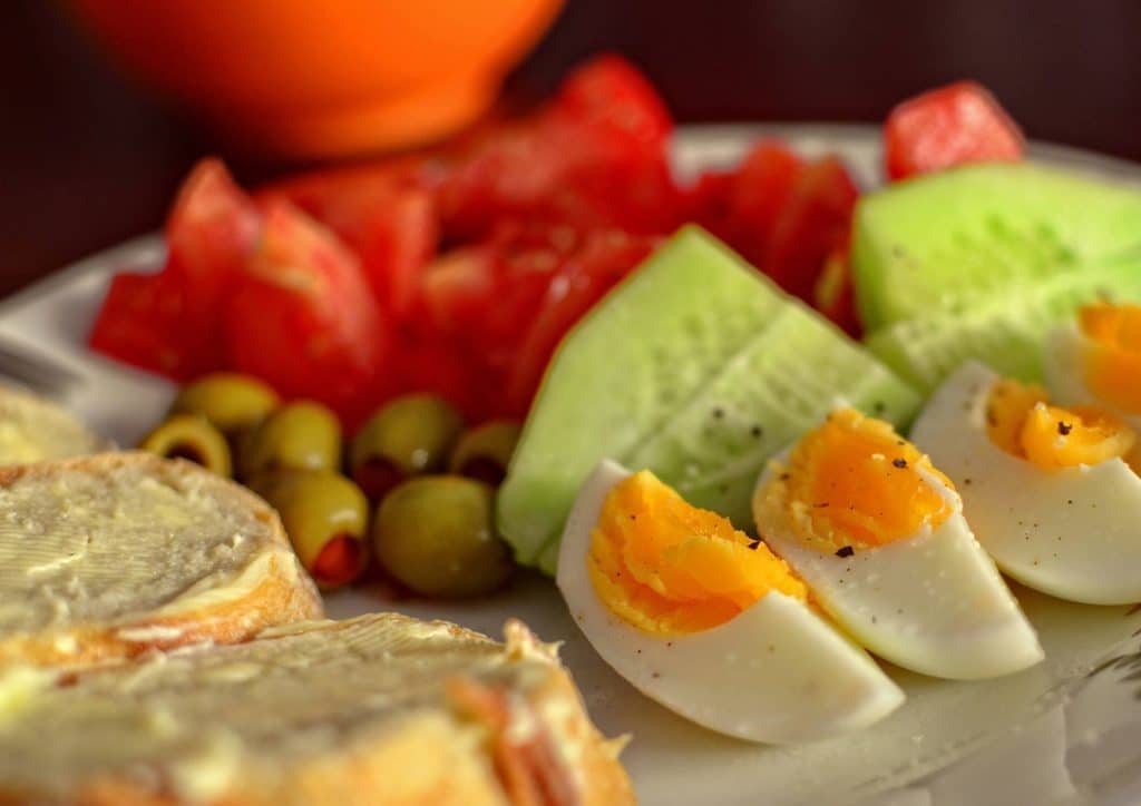 Easy Meals for Weight Loss When You're Short on Time 23 A plate featuring scrambled eggs, sliced tomatoes, and toasted bread arranged neatly.