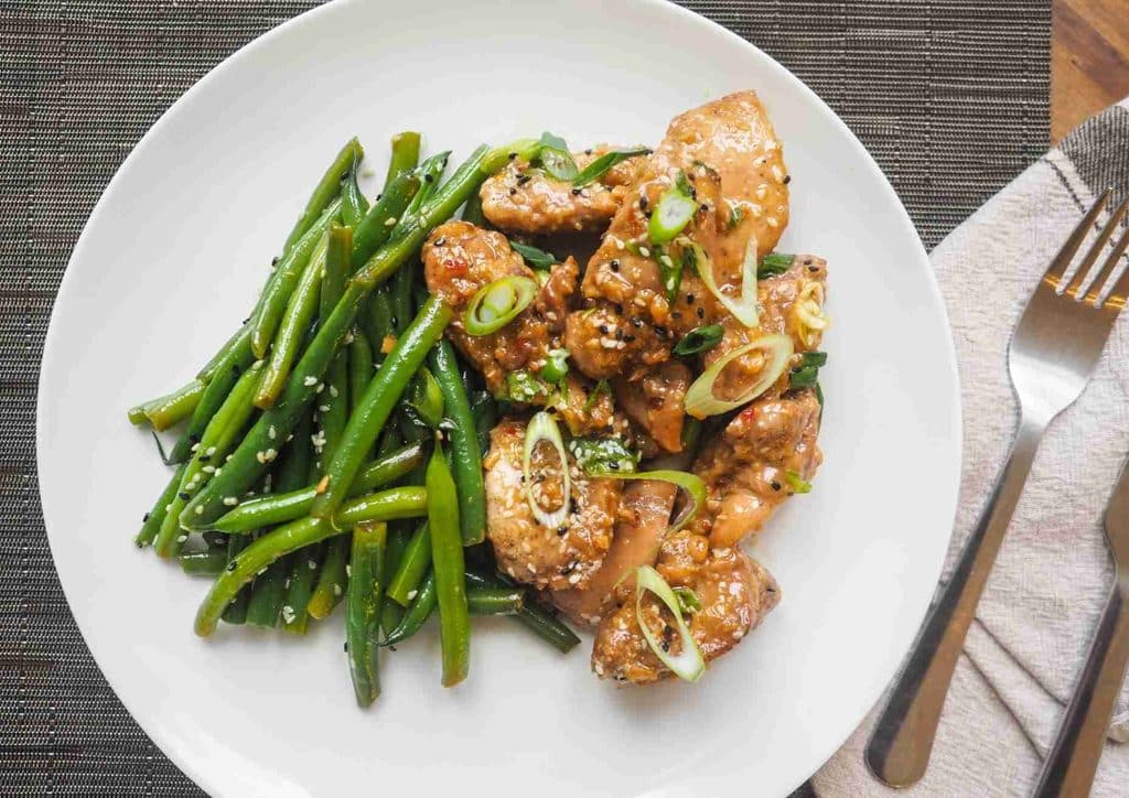 Healthy Dinners for Weight Loss: Easy Weeknight Ideas 15 A plate of chicken served with green beans, garnished with sesame seeds for added flavour and texture.