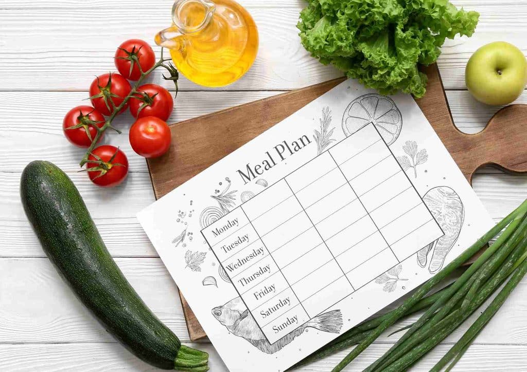 Healthy Meal Plans for Weight Loss: How to Build One That Lasts 3 A meal plan displayed on a cutting board, surrounded by fresh vegetables and various cooking ingredients.