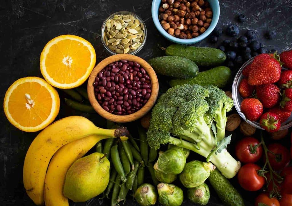 High Fibre Diet for Weight Loss: Why Fibre Keeps You Full 20 Bowls filled with an array of fresh fruits and vegetables, highlighting their vibrant colours and diverse textures.