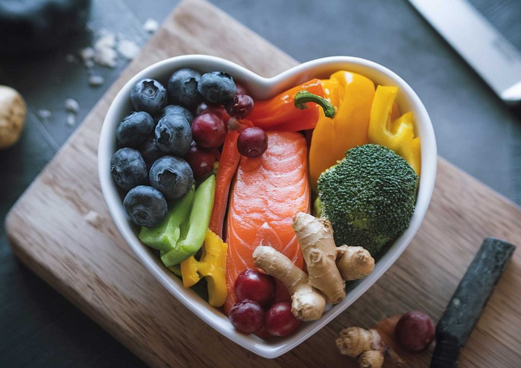 Losing Weight While Breastfeeding: What's Safe and Realistic 31 A heart-shaped bowl filled with an array of fruits and vegetables, emphasing health and nutrition.