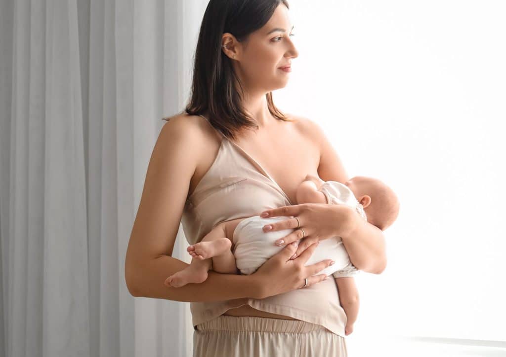 Losing Weight While Breastfeeding: What's Safe and Realistic 67 A woman gently cradles a baby in her arms, showcasing a tender moment of care and affection.