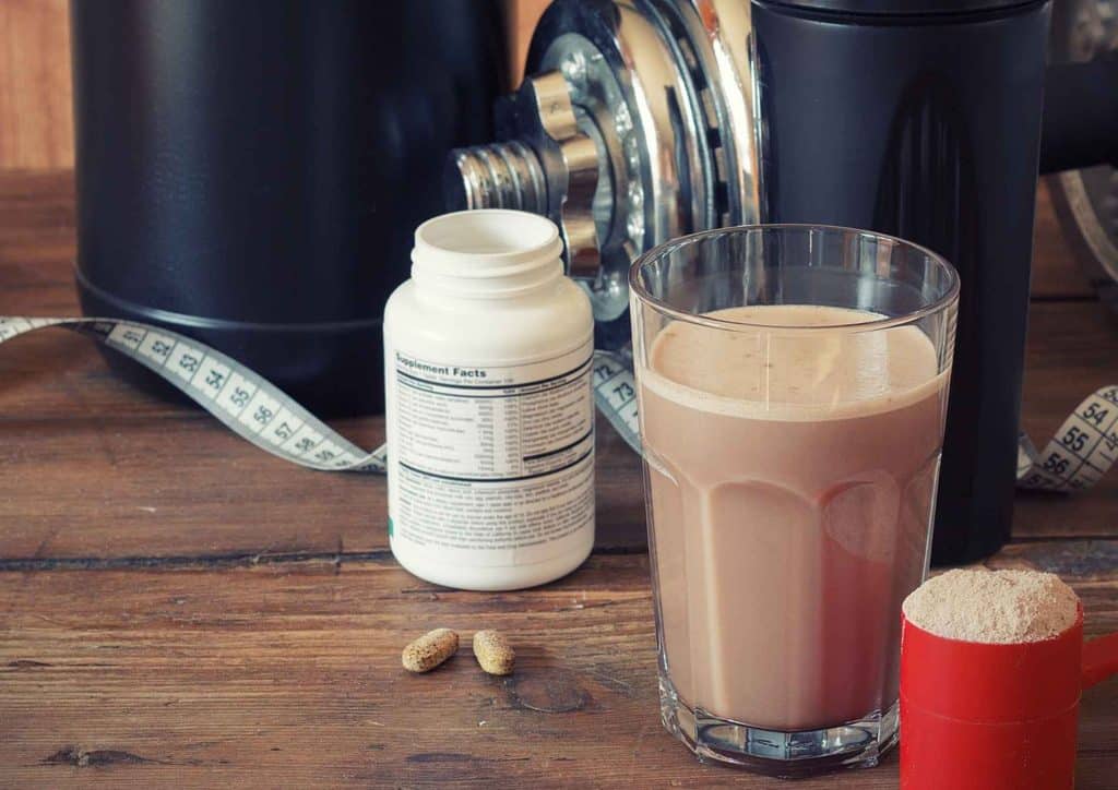 Is Whey Protein Good for Weight Loss? 24 A glass of protein shake beside a container of protein powder on a wooden surface.
