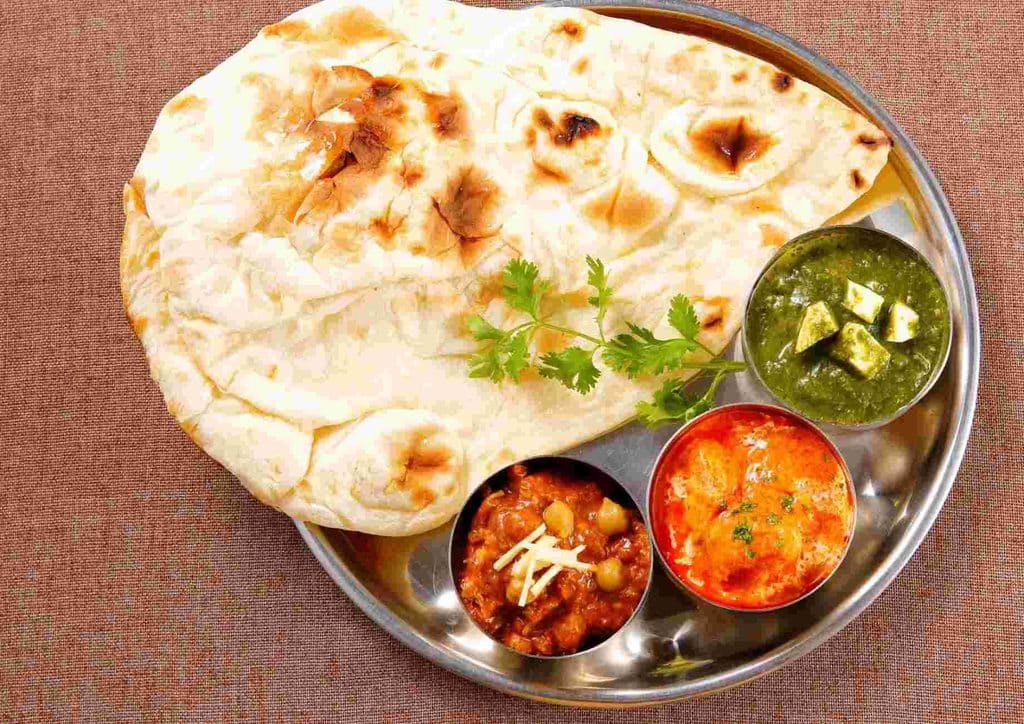 High Fibre Diet for Weight Loss: Why Fibre Keeps You Full 19 A plate featuring naan bread, a bowl of sauce, and a bowl of mixed vegetables arranged attractively.