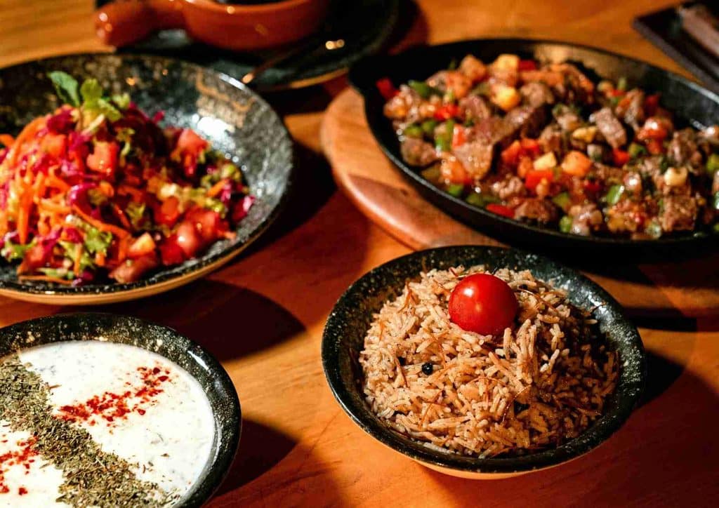 Is the Mediterranean Diet Good for Weight Loss? 7 A dining table displaying an assortment of food bowls, featuring a bowl of rice among them.