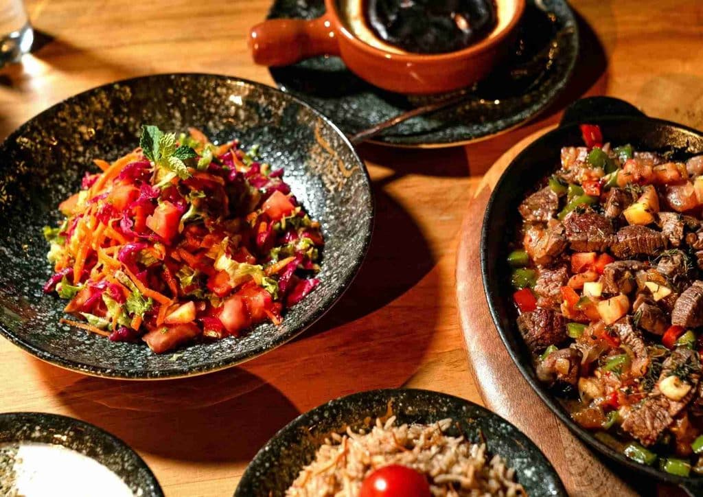 High Fibre Diet for Weight Loss: Why Fibre Keeps You Full 18 A dining table displaying an assortment of food plates and bowls of sauce, inviting for a meal gathering.