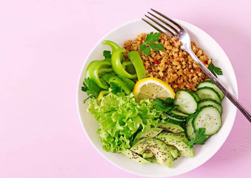 Easy Meals for Weight Loss When You're Short on Time 15 A bowl filled with fresh cucumbers, lettuce, and assorted vegetables, showcasing a colourful and healthy meal.