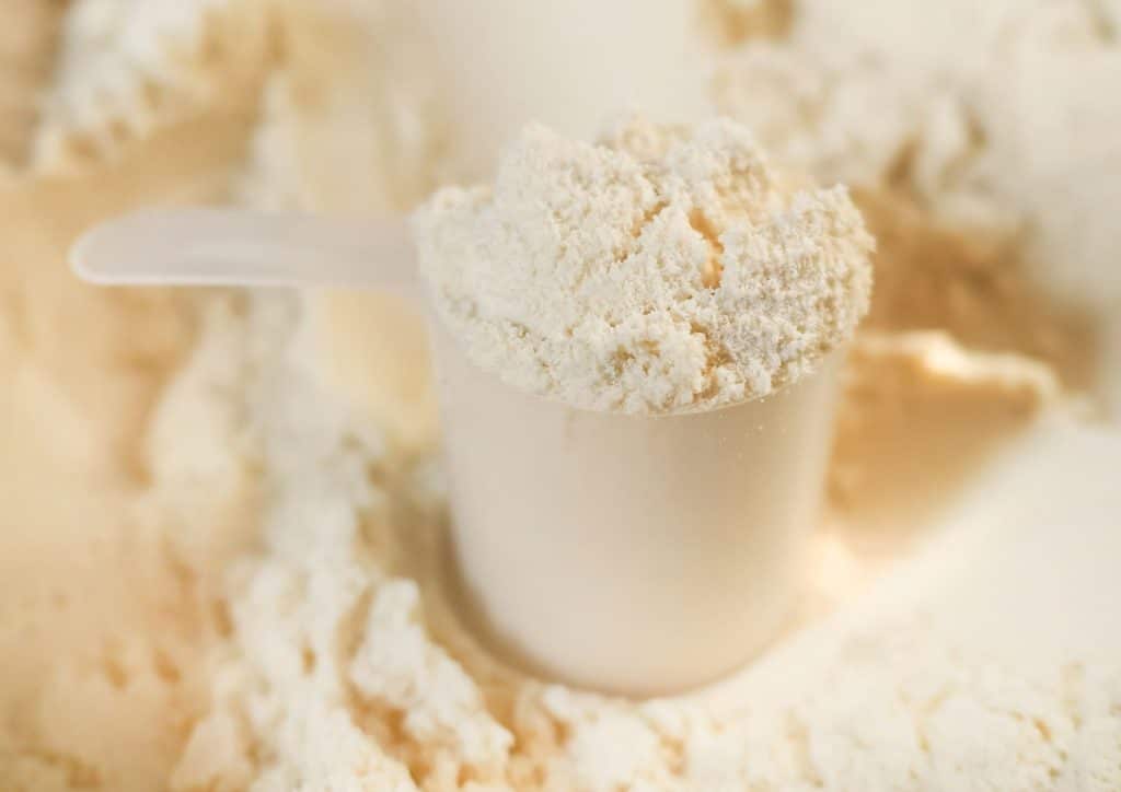 Is Whey Protein Good for Weight Loss? 20 A scoop filled with powder rests atop a larger mound of white powder.