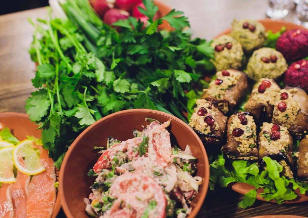 Vegetarian Diet for Weight Loss: How to Get It Right 54 A table set with an array of colourful dishes, including salads, meats, and desserts, ready for a meal.