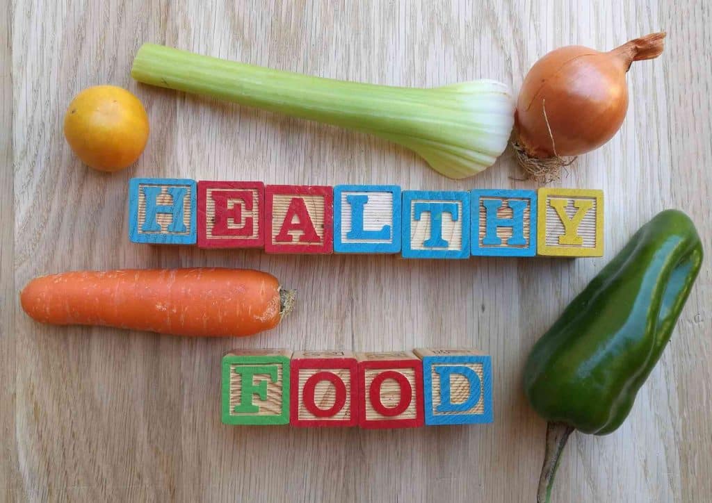 Healthy Dinners for Weight Loss: Easy Weeknight Ideas 41 Wooden table featuring block letters that read "healthy food," promoting wellness and nutritious eating.