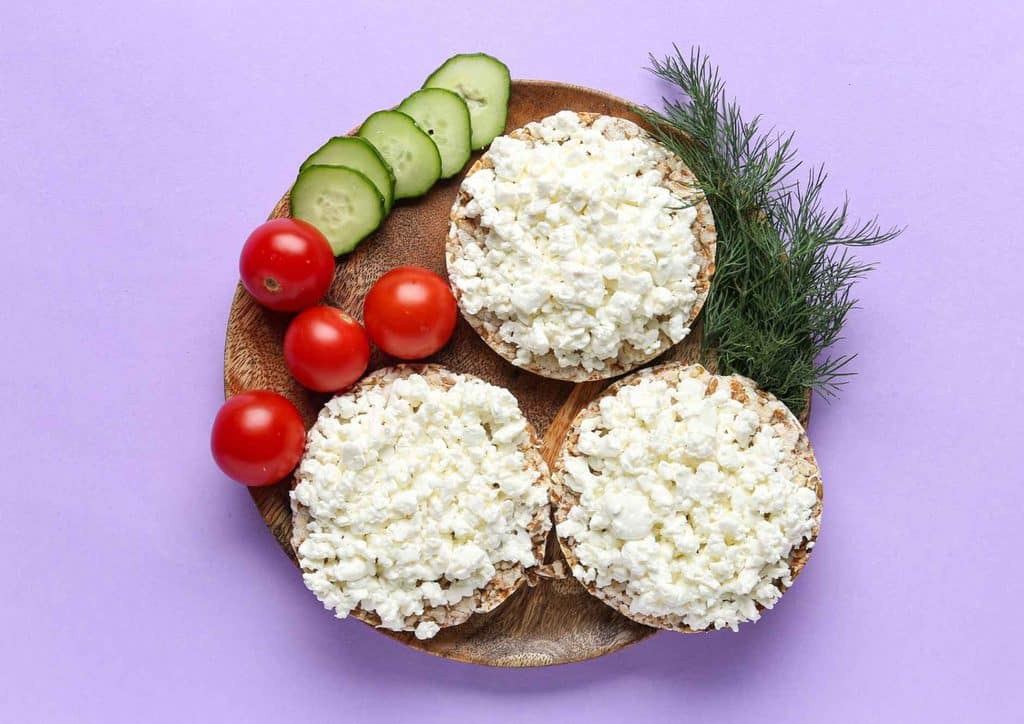 Healthy Snacks for Weight Loss That Actually Keep You Full 22 A plate featuring three slices of bread topped with crumbled feta cheese.